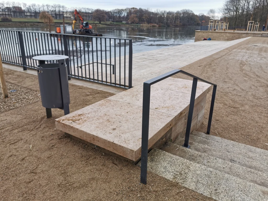 Kleine Natursteintreppe mit Metallgeländer am Ufer des Richard-Wagner-Hains, Leipzig.
